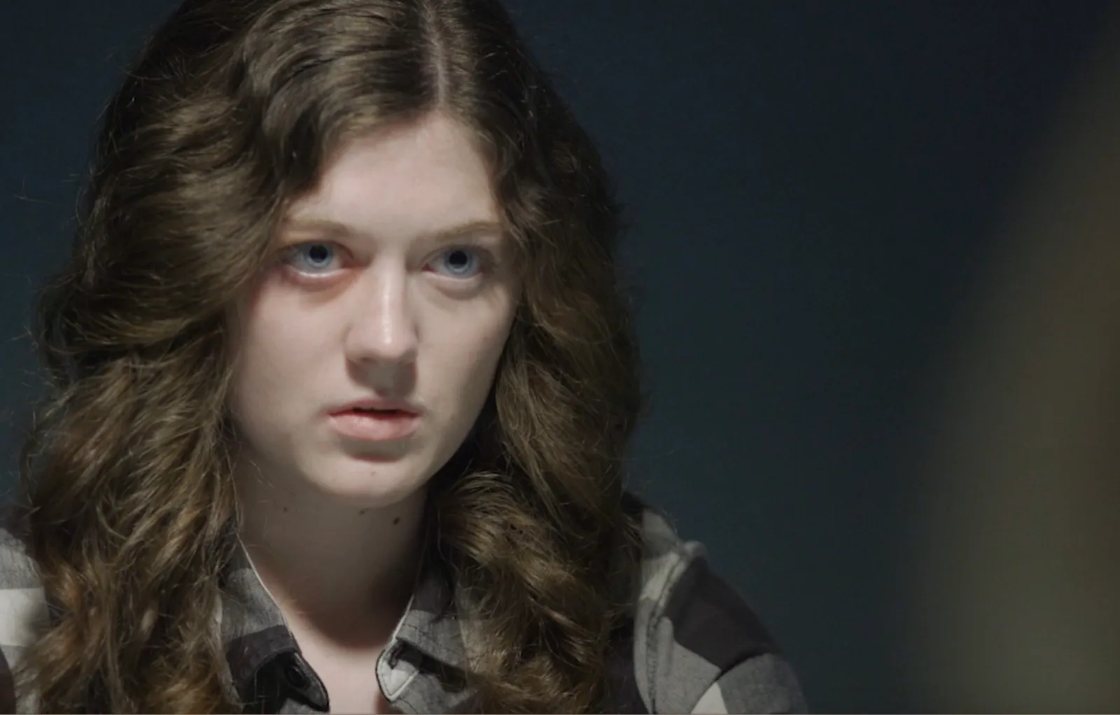 Film still of Krystina in a dramatic scene, looking intently past the camera